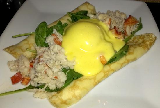 Cheese-filled crepes topped with spinach, lobster, and blue crab meat, with a poached egg and Hollandaise