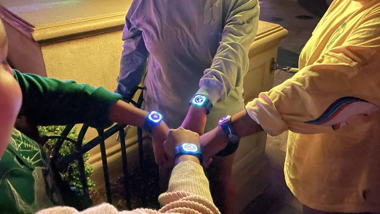Cast members showing off their new MagicBands after World of Color
